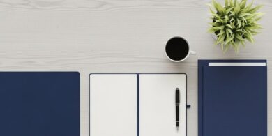 窓辺のデスクにノートと書類フォルダ、万年筆を並べた俯瞰イメージ。在留カードの紛失・盗難時の再交付手続きの準備を象徴。