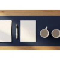 書類とコーヒーカップ、観葉植物を並べた明るい家庭のテーブルの俯瞰イメージ。家族が日本で一緒に暮らすことを象徴する記事アイキャッチ。