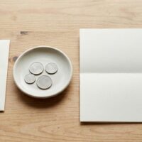 2026年10月1日に改定される在留許可手数料の準備を象徴する、机に置かれた無地の封筒と用紙とペンのイメージ