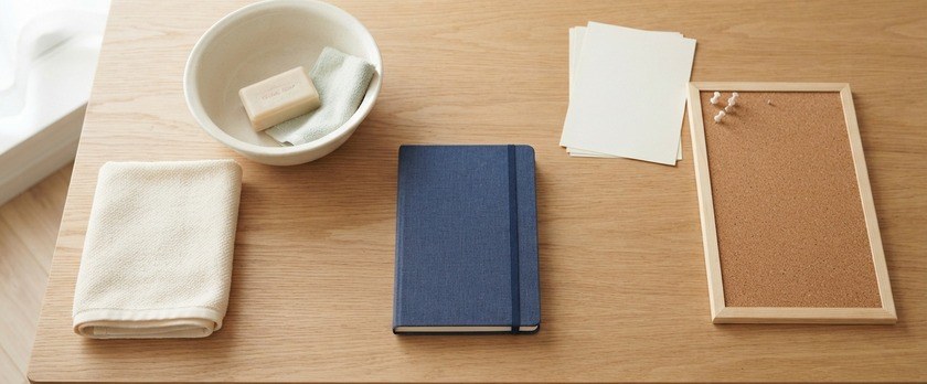 タオルと洗面器、無地の掲示板と手帳を並べた俯瞰イメージ。特定技能・介護分野の「身体介護」と「関連業務」の区別を象徴。