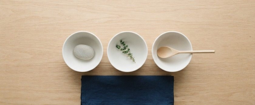 白い小鉢を3つ並べ、それぞれに小石・ハーブ・木のスプーンを置いた俯瞰イメージ。停止中でも取れる選択肢があることを象徴。