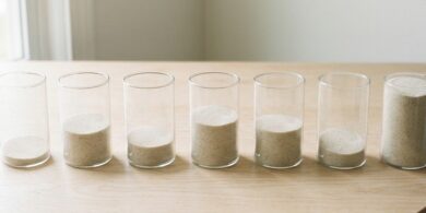 中身の量が異なる無地の容器を並べた俯瞰イメージ。特定技能の分野別の受入れ枠の残りを象徴。