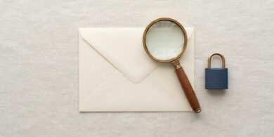 無地の封筒を虫眼鏡で確かめている俯瞰イメージ。入管を装った詐欺メールを見分けることを象徴。