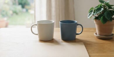 無地のマグカップ2つと無地のフォルダーを並べた机のイメージ。夫婦で暮らし続けるための配偶者ビザの更新を象徴。