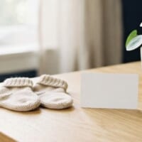 小さな靴下と無地のカードを並べた机のイメージ。子どもの在留カードの手続を象徴。
